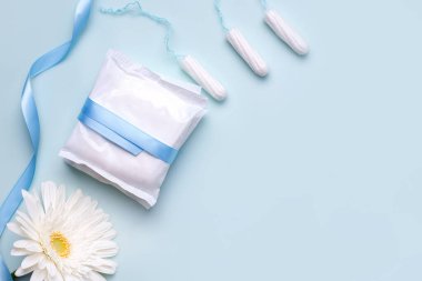 Regl döneminde korunma kavramı. Mavi arka planda iç çamaşırı ve tamponlar.