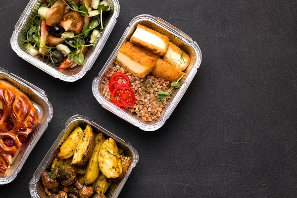 Lieferkonzept nach Hause. Auf schwarzem Grund Brei mit Gemüse, Kartoffeln und Pilzen, Salat. Kopierraum — Stockfoto