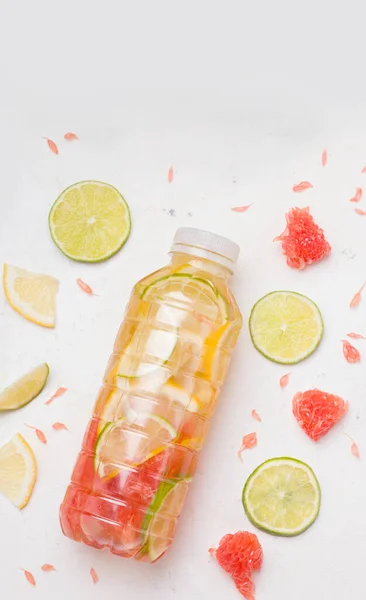 Sports drink in a bottle with lime, lemon and grapefruit
