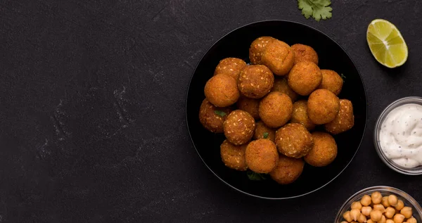 Falafel Middle Eastern vegan dish over black background. Copy space