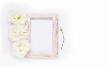 Modelleme. Tahta fotoğraf çerçevesi beyaz çiçeklerin yanında. Boşluğu kopyala