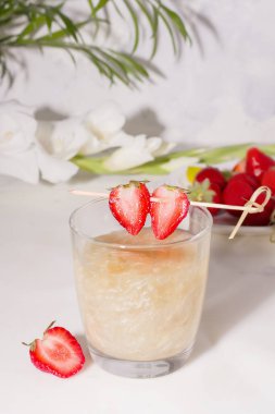 Drink with a shiny shimmer in a glass decorated with strawberry wedges clipart