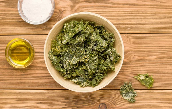 Kale chips op een houten tafel. Zicht van bovenaf. Landelijk — Stockfoto