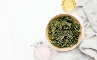 Beyaz bir masada kasede lahana cipsi. Yukarıdan bak. Boşluğu kopyala