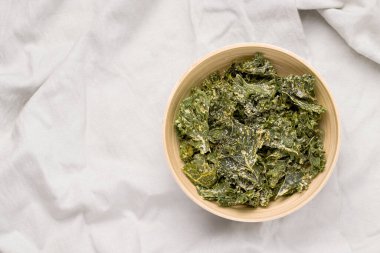 Gri arka planda bir kasede lahana cipsi. Yukarıdan bak. Boşluğu kopyala