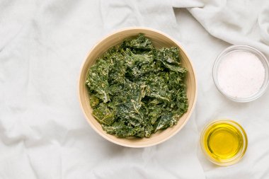 Gri masa örtüsündeki malzemelerin yanında lahana cipsi var.