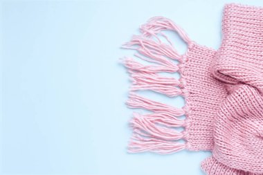 Mavi arka planda pembe, sıcak örülmüş bir eşarp. Uzayı kopyala Yukarıdan bak. Pankart