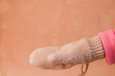 Kahverengi arka planda sıcak bir eldiven verin.