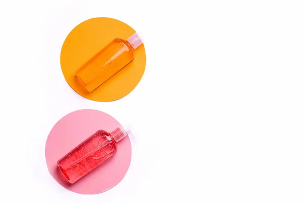 Engañar jabón de gel líquido. Botella naranja y rosa sobre fondo blanco. Copiar espacio —  Fotos de Stock