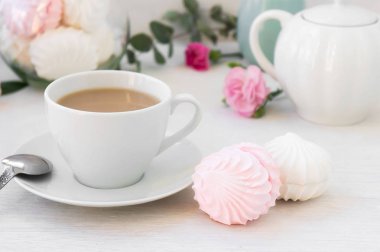 Bir fincan kahve ve iki ev yapımı beyaz ve pembe marshmallow zephyr ile kahvaltı nazik bir sabah. Seçici odaklama.