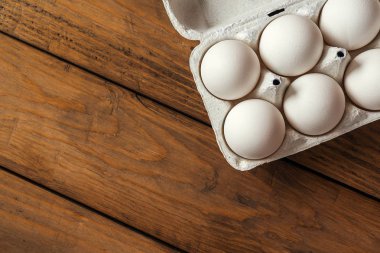 Ahşap arka planda beyaz yumurtalar. Üstte görüntü