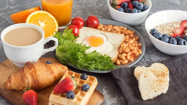 Desayuno inglés completo con huevos fritos, frijoles, tostadas, ensalada, tomates sobre fondo gris — Foto de Stock