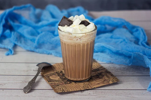 Heiße Schokolade oder Kakao im Glas mit Schlagsahne und Schokoladenstücken — Stockfoto