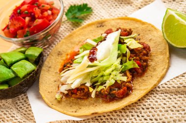 Meksika geleneksel ev yapımı domuz etli, acılı, acılı, domates salatası, avokado soslu ve soslu tako.
