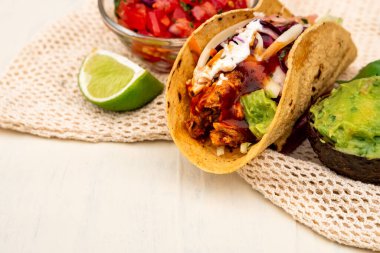 Meksika geleneksel ev yapımı domuz etli, acılı, acılı, domates salatası, avokado soslu ve soslu tako.