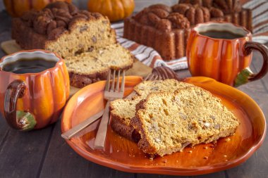 İki bardak kahve ve taze pişmiş somun ekmek ahşap masa üzerinde kabak plaka üzerinde oturan dilimleri cevizli kabak iki dilim ekmek