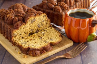 Arka plan ve kabak kupa kahve tam somun ile ahşap kesme tahtası üzerinde oturan kabak ekmek dilimlenmiş