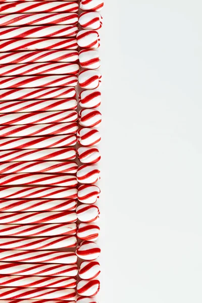 背景的红色和白色薄荷棒和旋转糖果球与空白在右边 — 图库照片