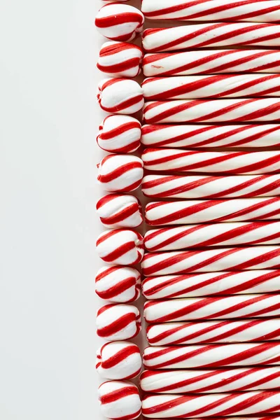 平躺在红色和白色薄荷棒和旋转糖果球与空白在左边的背景 — 图库照片