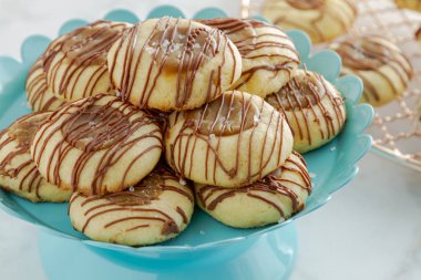 Tanımlama bilgilerini sütlü çikolata parlak mavi pasta sandalyesinde oturan ile drizzled tuzlu karamel parmak izi, yakın çekim