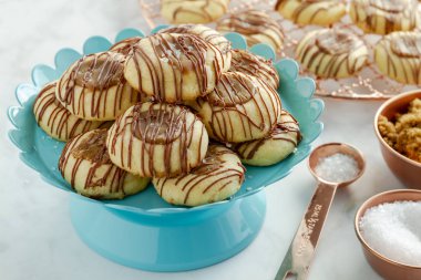 Tuzlu karamel parmak izi tanımlama bilgilerini sütlü çikolata malzemeler ile çevrili parlak mavi pasta stand üzerinde oturan ile drizzled
