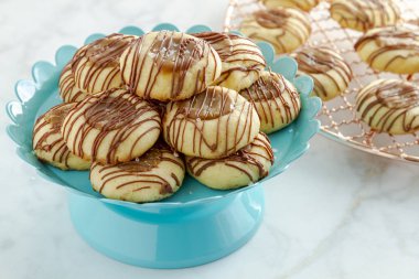 Tuzlu karamel parmak izi tanımlama bilgilerini sütlü çikolata parlak mavi pasta ve raf arka planda soğutma bakır oturan ile drizzled