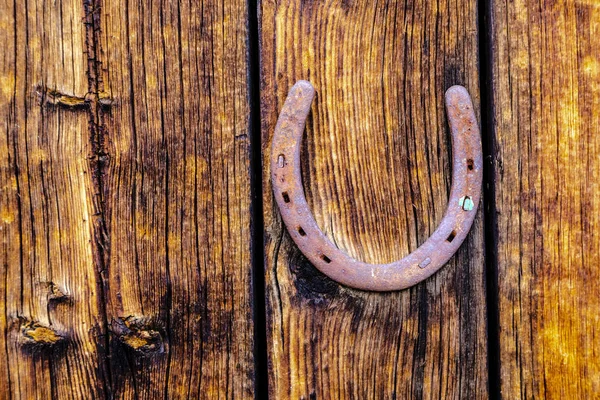 Rusty horseshoe on weathered wood — Stock Photo, Image
