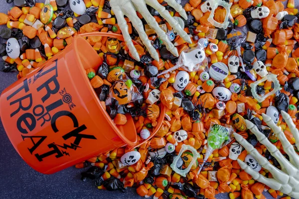 Halloween candy spilling out of orange trick or treat bucket