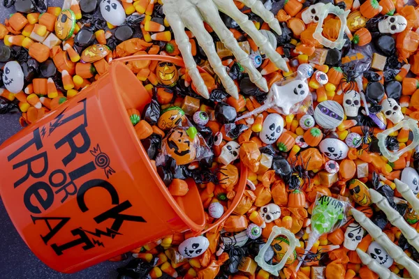 Halloween candy spilling out of orange trick or treat bucket — Stock Photo, Image