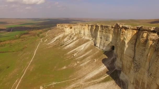 Wandelen door de lucht naast de krijtachtige gebarsten rotsen. Birds eye view. — Stockvideo