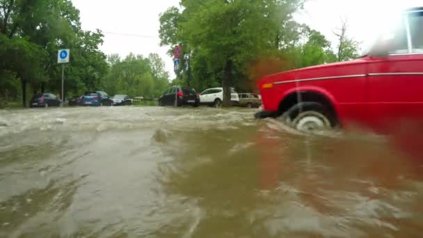 Coches pasando por una intersección inundada — Vídeo de stock