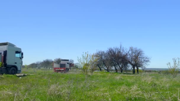 Dos camiones salen uno tras otro a lo largo del camino — Vídeos de Stock