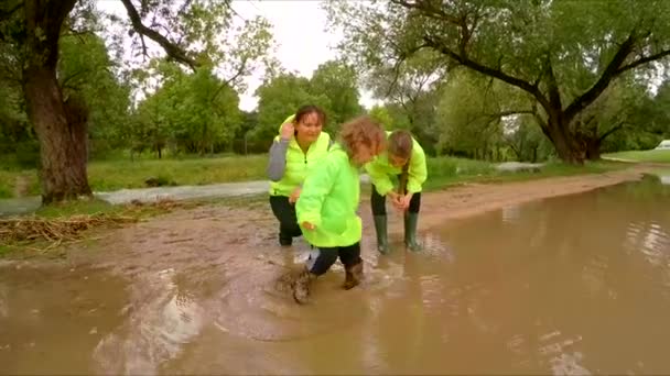 Çocuk ayaklarıyla su birikintisi içine gitmek için izin verildi — Stok video