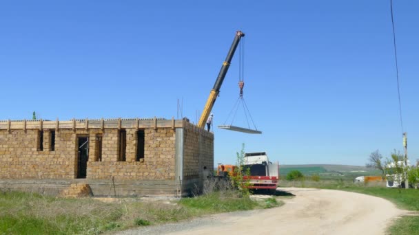 移动式起重机将混凝土板拖到未完工的房子 — 图库视频影像