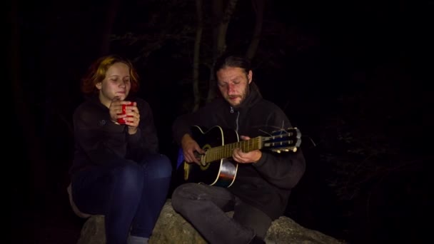 Pareja romántica jugando guitarra en hoguera — Vídeos de Stock