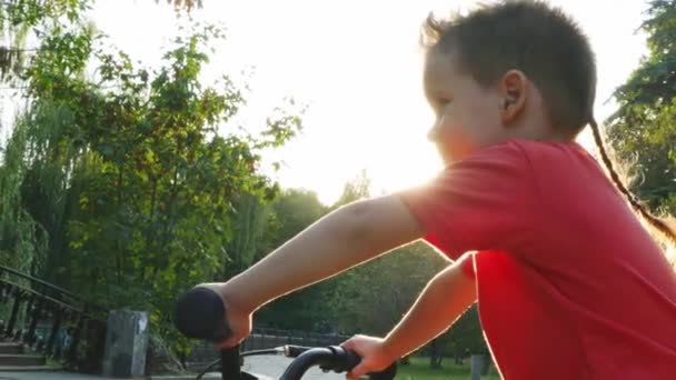 Niño sentado en una bicicleta — Vídeos de Stock