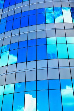 Beyaz bulutlar modern ofis gökdelen doku ve bacgound uzun cam mavi soyut ürün üzerinde güneş ışığı yansıtacak.