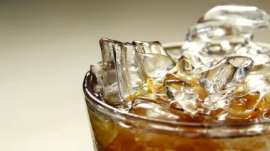 4K Whiskey siyah arka planda bir bardağa dökülüyor. Makro.