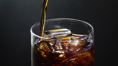 4K, bir bardağı Coca ile dolduruyor. Gazozda baloncuklar, kırmızı destansı, bardaktan aşağı akan su damlaları, cızırdayan köpük, buzlu bardak.