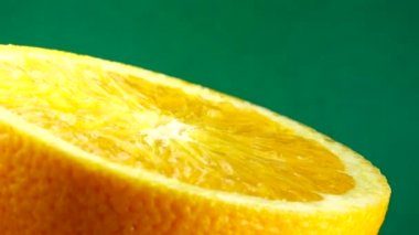 4k Macro portakal suyu ve dönüş. Taze turuncu turunçgil yeşili arkaplanı kapat..