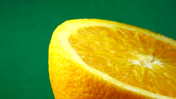 4Kネーブルオレンジの果実と回転のマクロショット 新鮮な柑橘類を閉じますオレンジグリーンの背景 — ストック動画