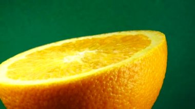 4k Macro portakal suyu ve dönüş. Taze turuncu turunçgil yeşili arkaplanı kapat..