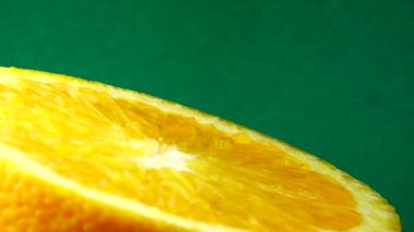 4k Macro portakal suyu ve dönüş. Taze turuncu turunçgil yeşili arkaplanı kapat..