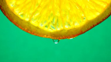 4k Macro shot. Göbek portakal suyu ve su damlası. Taze turuncu turunçgil yeşili arkaplanı kapatın..