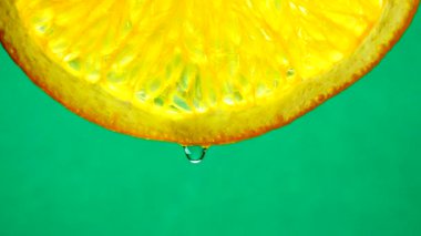 4k Macro shot. Göbek portakal suyu ve su damlası. Taze turuncu turunçgil yeşili arkaplanı kapatın..