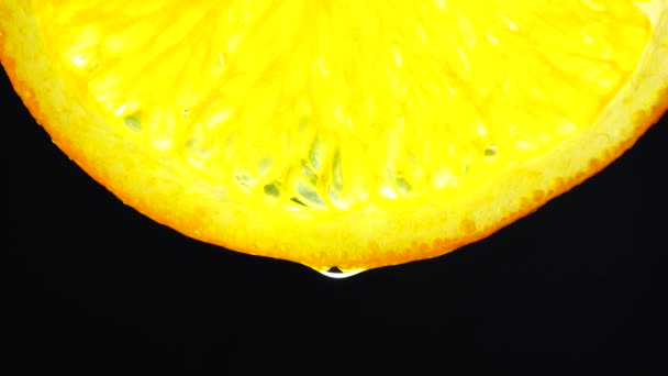 오렌지 열매를 자르고 떨어뜨리는 매크로 오렌지 배경을 닫는다 — 비디오