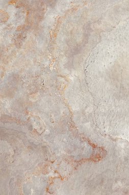 Gri ve paslı turuncu toprak tonlarına sahip doğal taş dokusu, kabataslak yüzey şekilleri ve organik detaylar sergiliyor, arka plan veya tasarım elementleri için ideal..