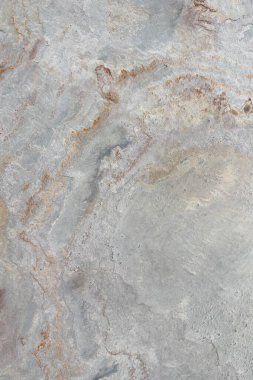 Gri ve paslı turuncu toprak tonlarına sahip doğal taş dokusu, kabataslak yüzey şekilleri ve organik detaylar sergiliyor, arka plan veya tasarım elementleri için ideal..