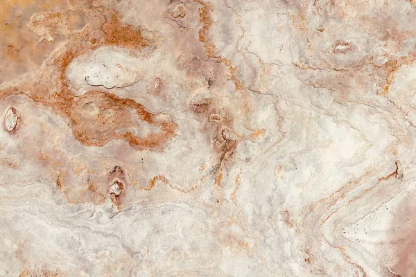 Gri ve paslı turuncu toprak tonlarına sahip doğal taş dokusu, kabataslak yüzey şekilleri ve organik detaylar sergiliyor, arka plan veya tasarım elementleri için ideal..