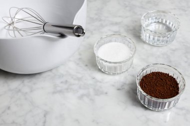 Bir mermer masanın üzerindeki Dalgona kahve malzemeleri: Anında kahve, şeker ve su